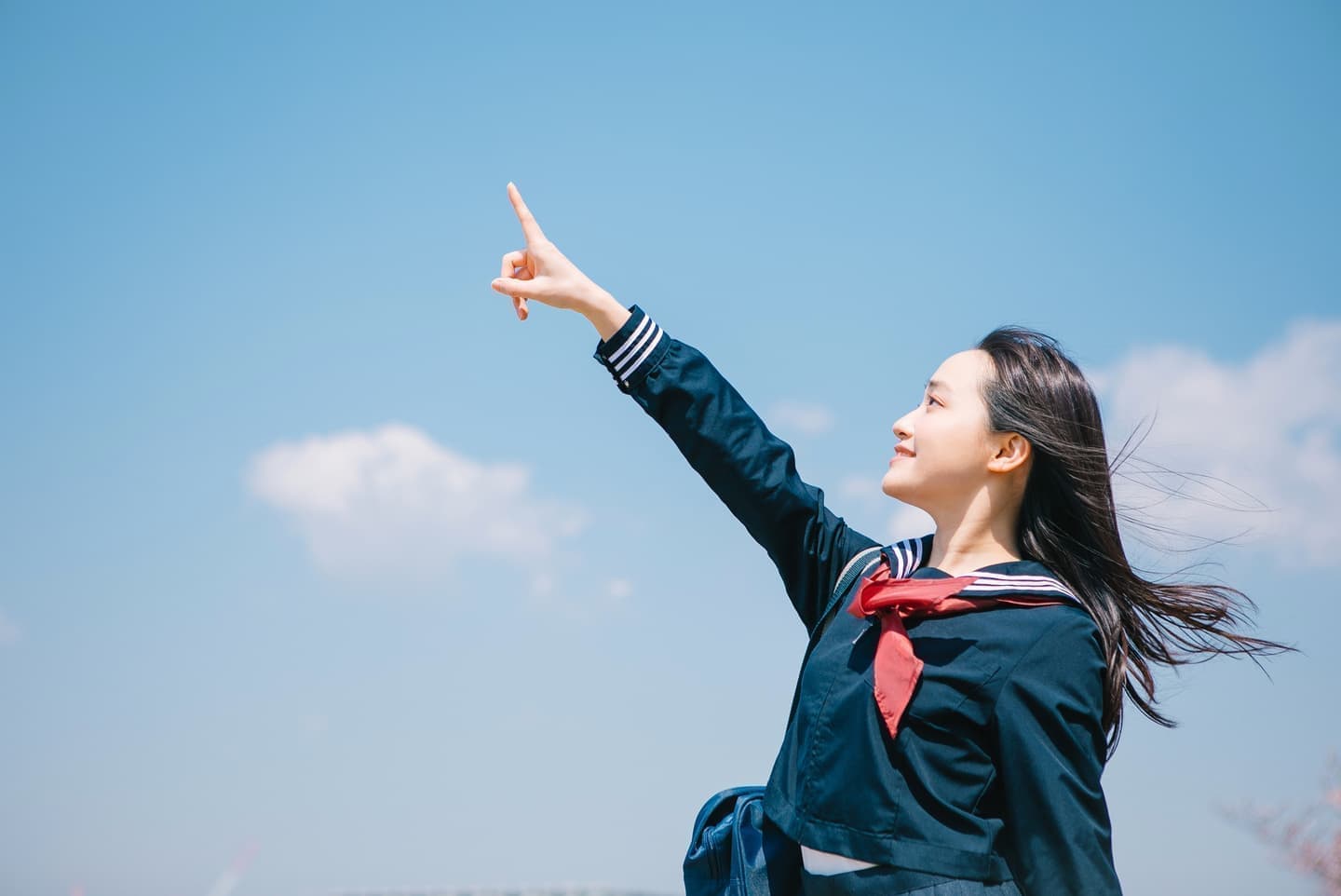 青空を指さす中学生